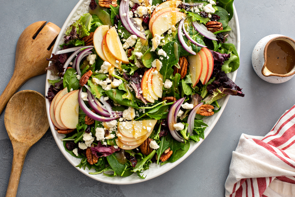 Winter salad with apple, red onion and roasted pecans with vinaigrette dressing